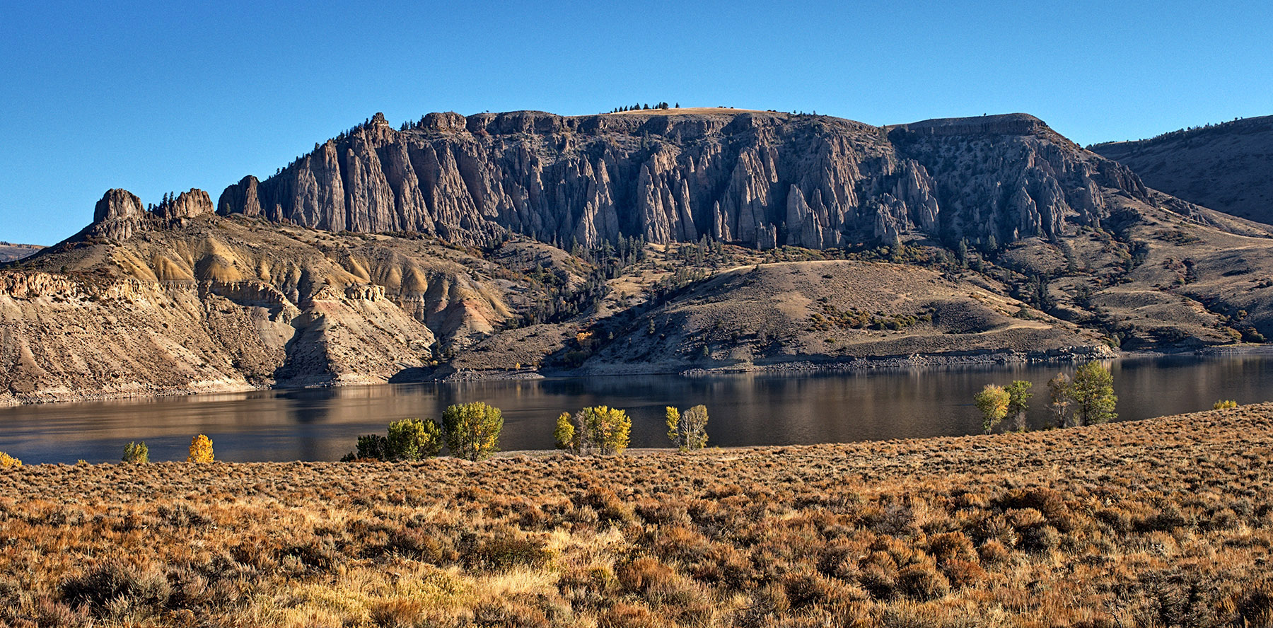 Partially-eroded pinnacles of West Elk breccia from mid-phase Tertiary volcanics rest on Mesozoic sediment above Blue Mesa Reservoir.