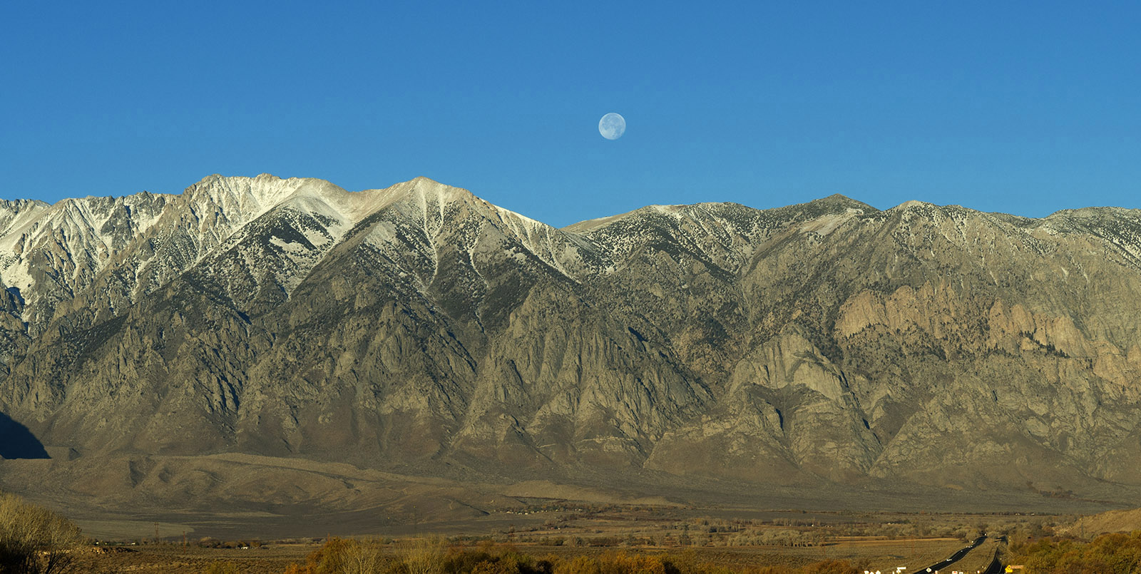 Sierra Nevada outside Bishop rises sharply from the Owens Valley.  Mountains are composed of granitic rock formed during the Mesozoic era (70-250 million years ago). Valley pulled away and sank relative to the Sierra Nevada during the Middle and Late Miocene epoch (7-20 million years ago).  The Sierran tilted fault block uplifted either in the late Mesozoic or Paleogene (25-90 million years ago) or in the Miocene and Pliocene epochs (3-25 million years ago).