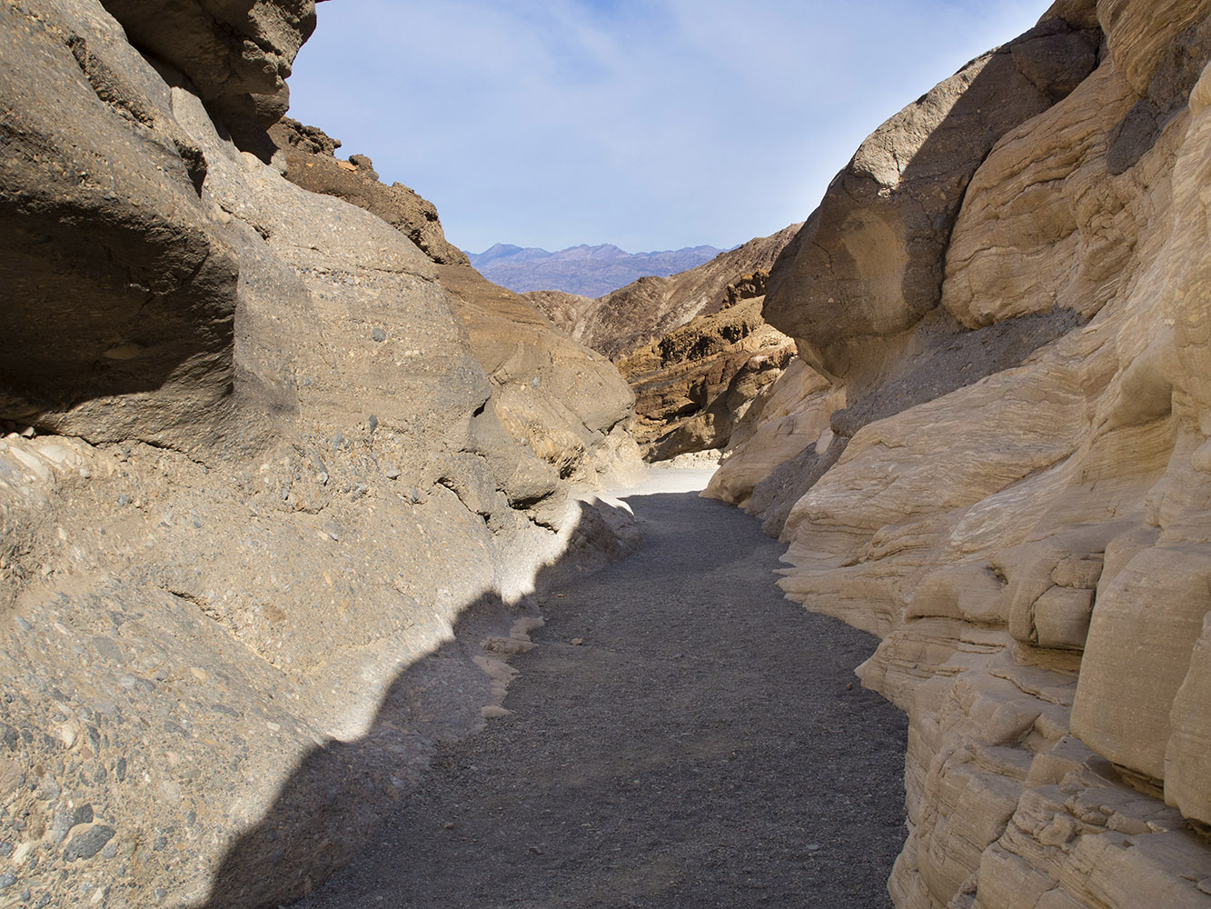 Mosaic Canyon narrow area.    West side on right is water erosion polished dolomite marble.  East side on the left is cemented dolomite breccia.