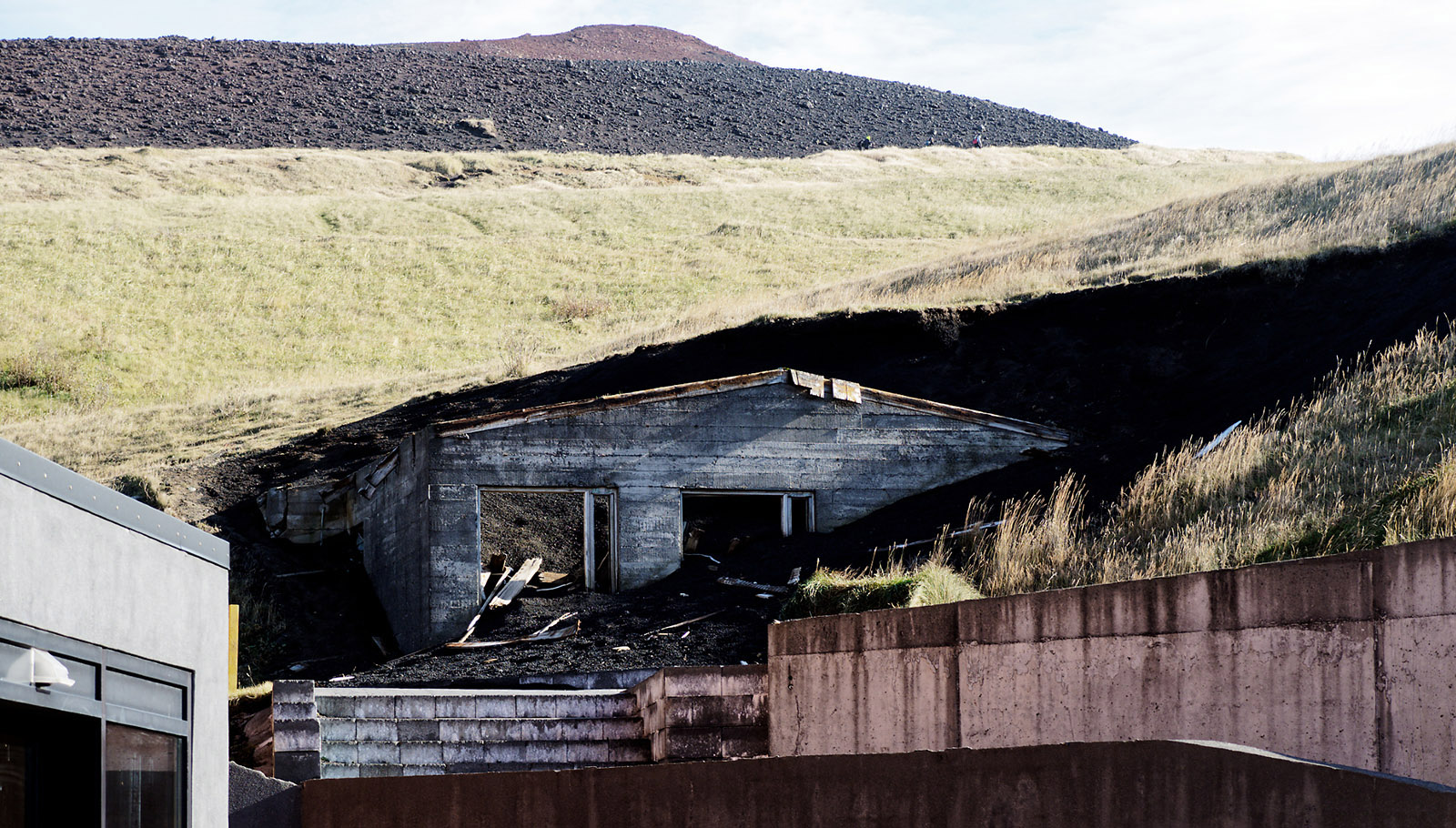 Remnant of destroyed house consumed by lava and tephra from the 1973 eruption.  It is adjacent to the Eldheimar, a museum with excellent physical, photographic and video exhibits on the Eldfell eruption, the evacuation, and on adjacent island-building eruptions (Surtsey).