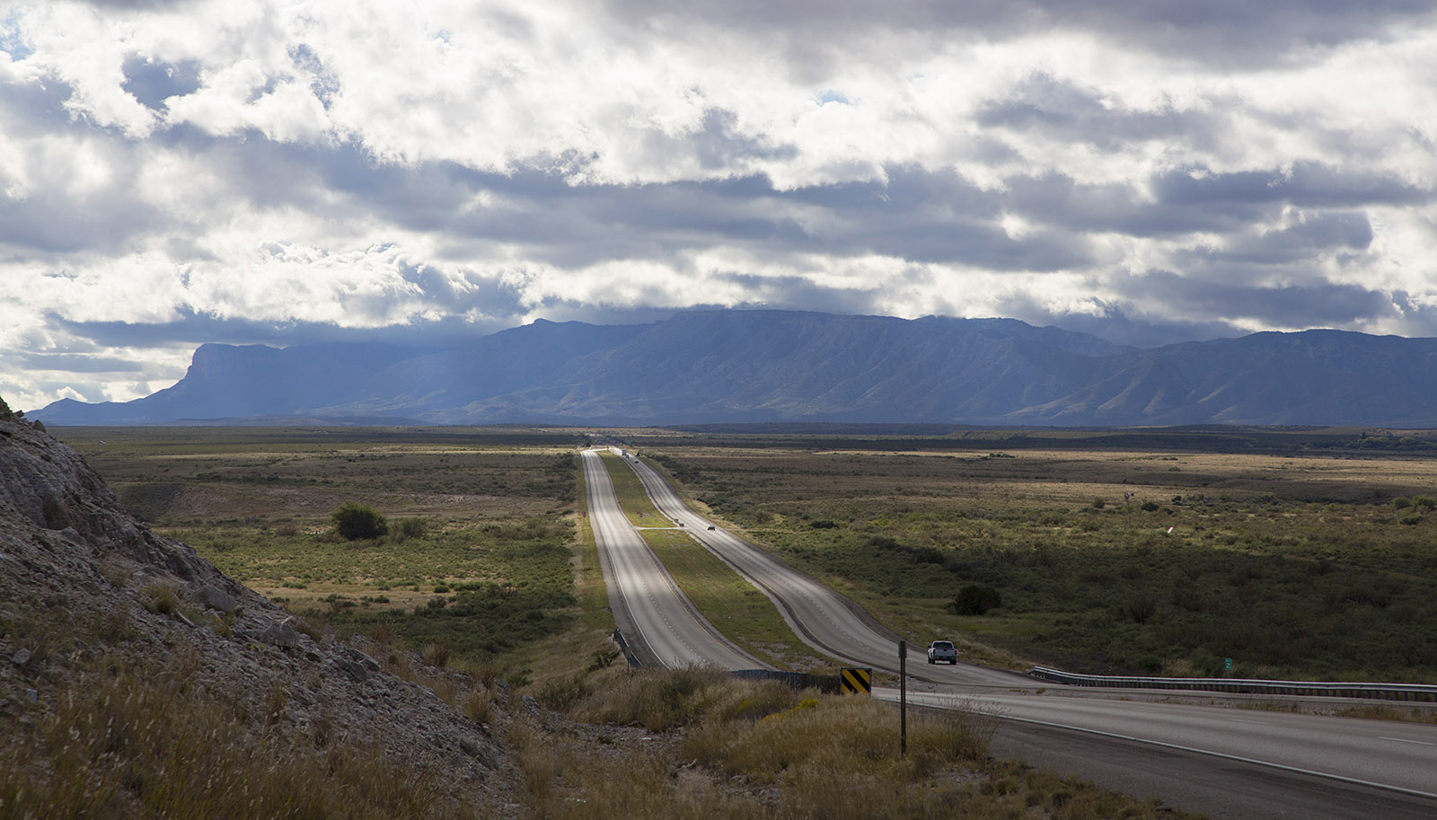 Guadelupe Mountains above the Delaware Basin with US Highway 62.; The basin is the previous floor of a large inlet of Permian sea.; The mountains are remnants of the tropical Capitan reef which formed 250 million years ago.